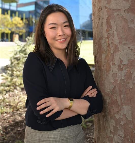 A lady named Charlotte standing next to a tree