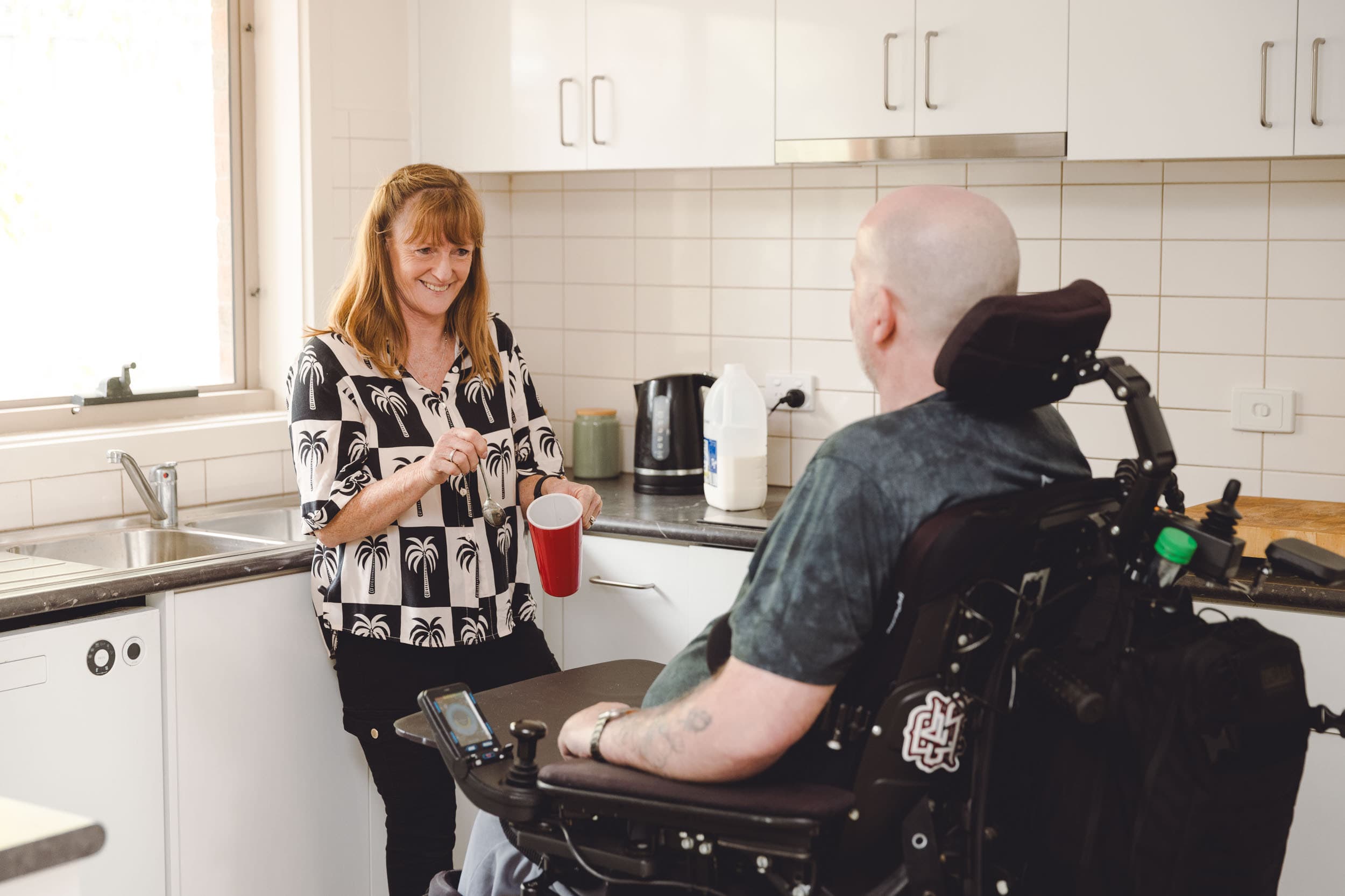 A support worker and a person living with multiple sclerosis inside Watsonia Home accommodation.