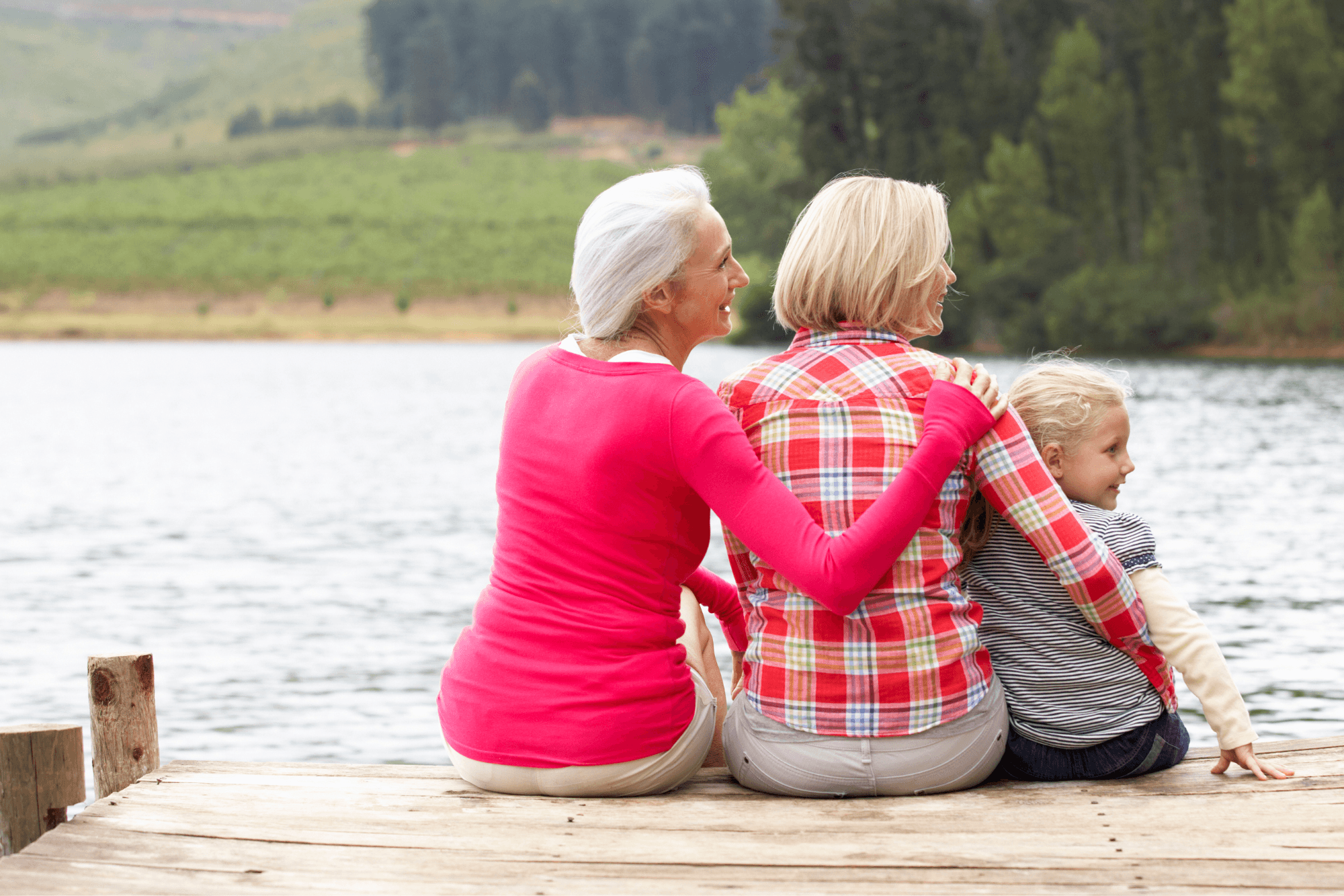 Two women sitting with a child by the waters