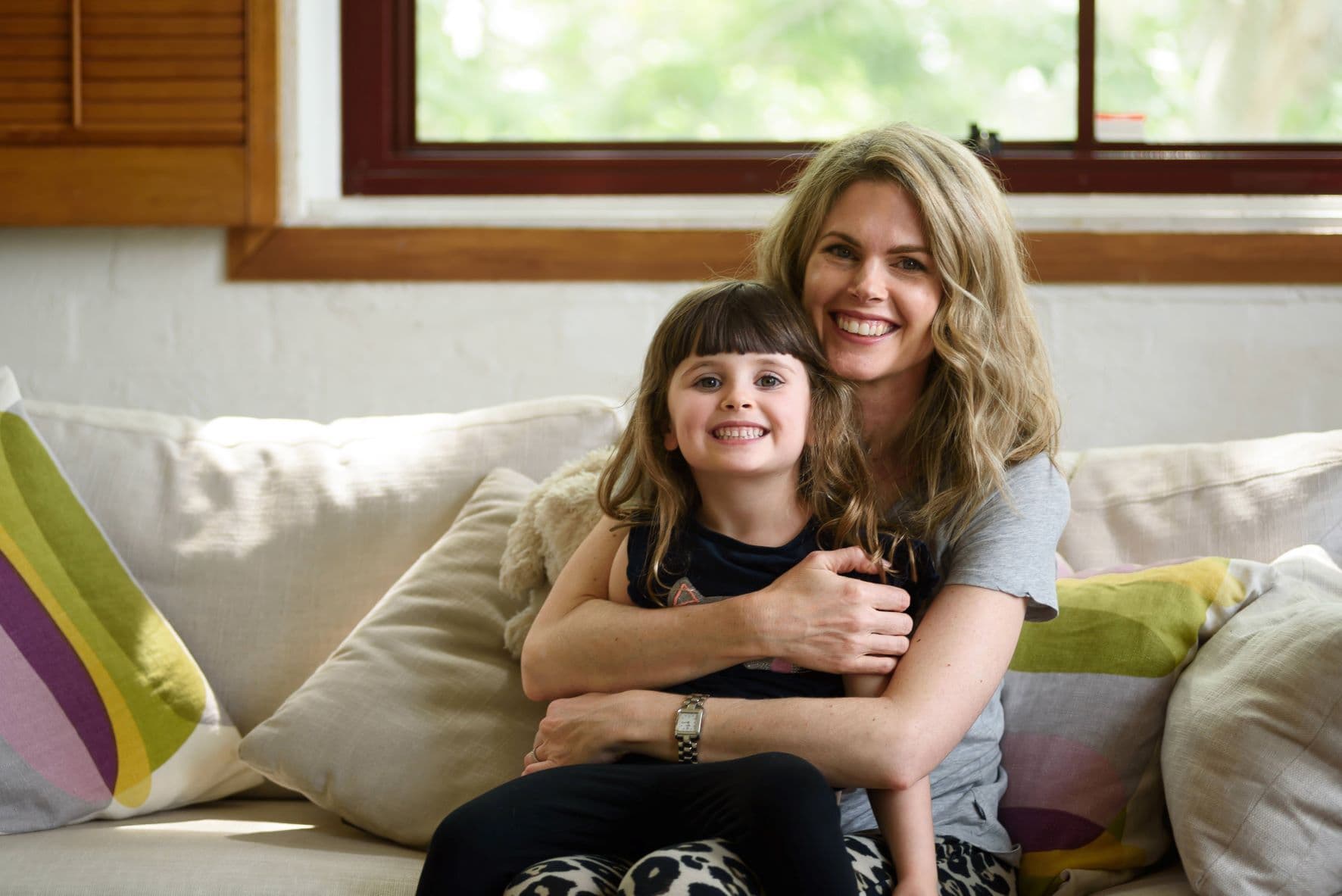 Emma poses with child on couch