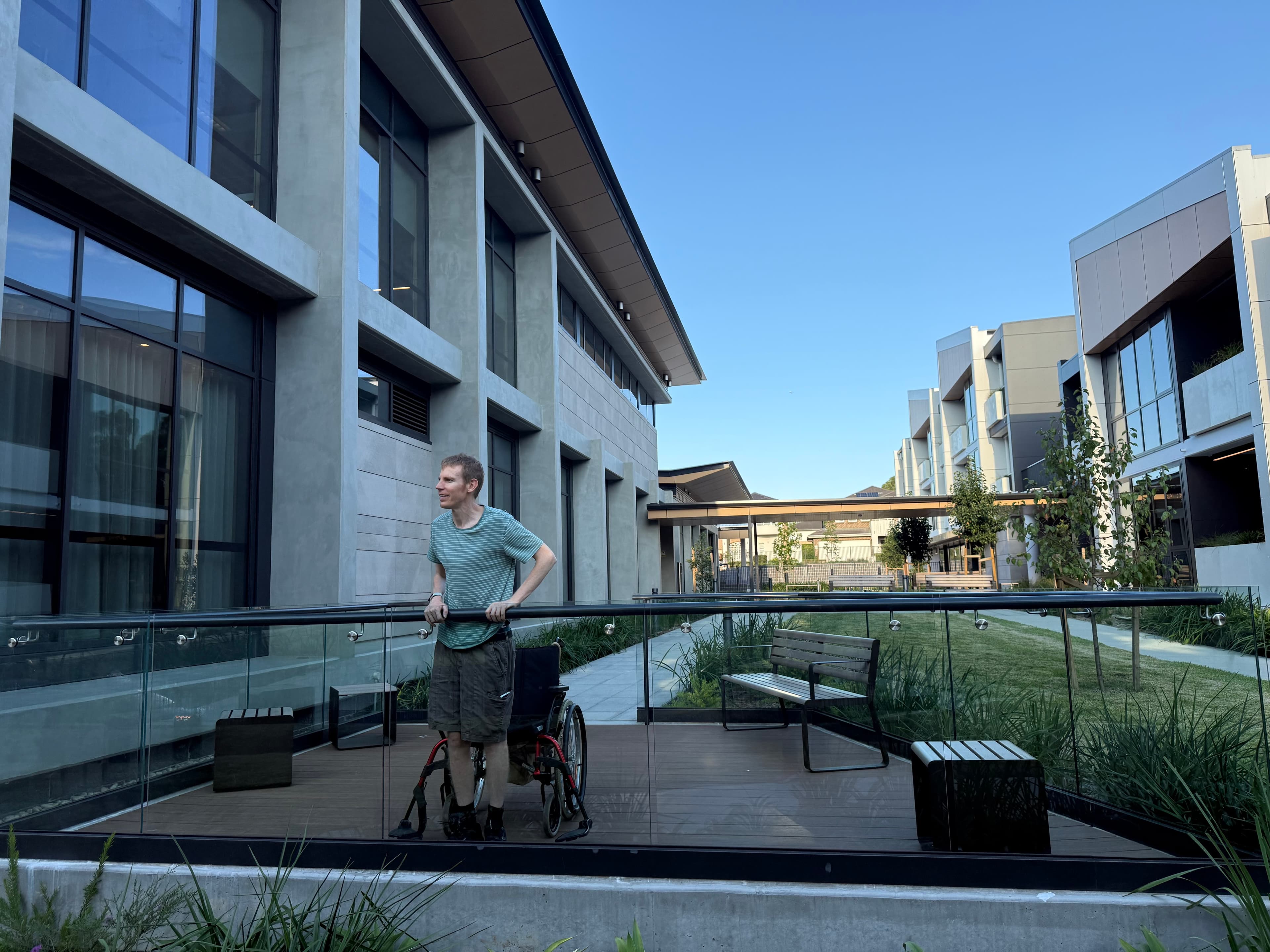 Aaron, a person living with MS standing outside the Lidcombe Home