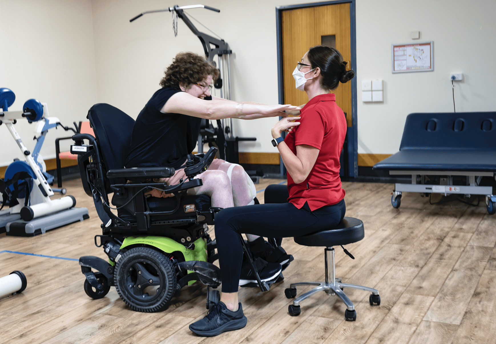 Caitlin supports a client with exercise