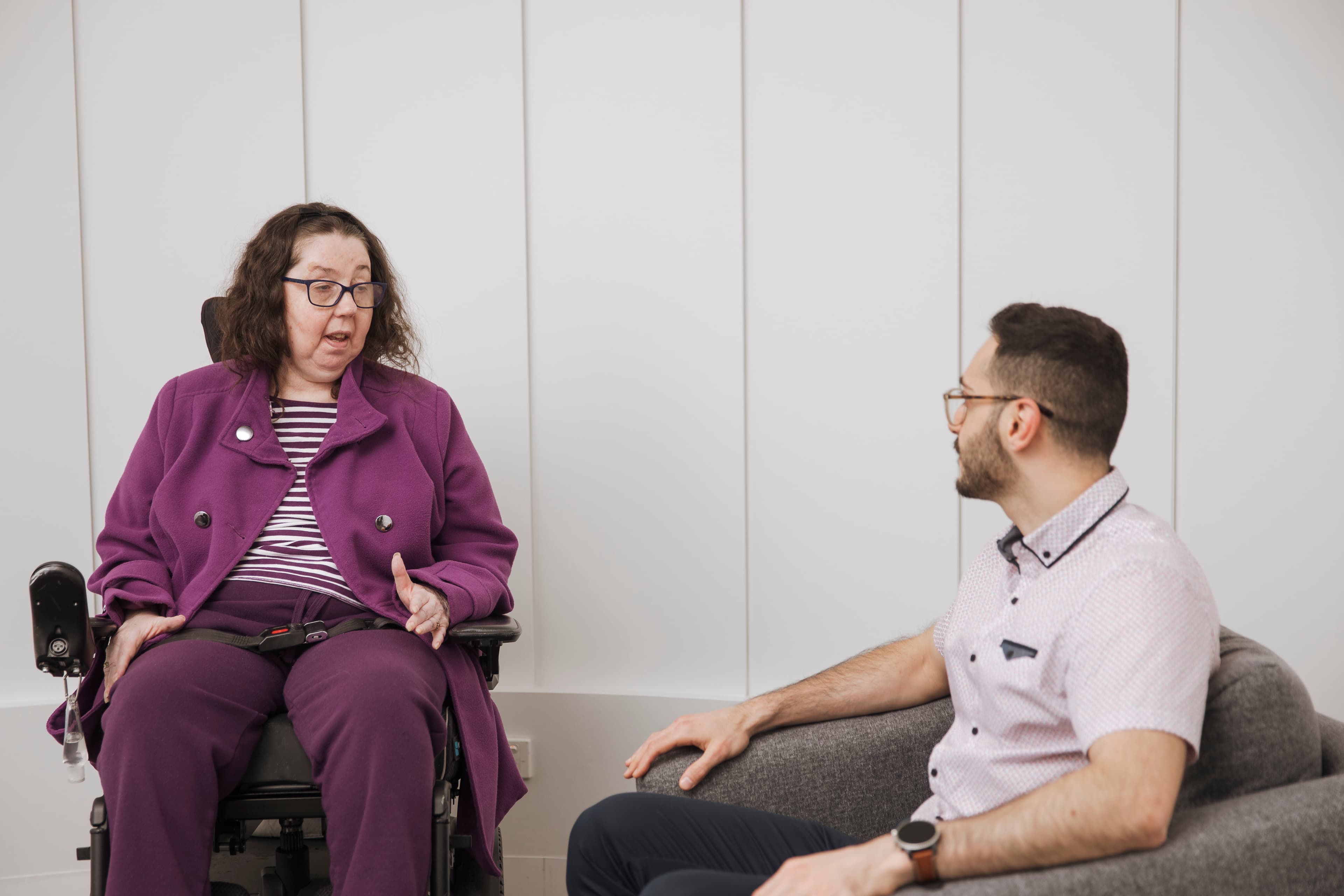 A woman in wheelchair speaking to a man