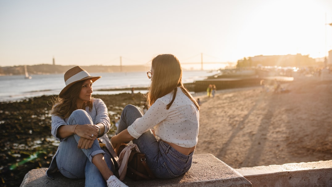 Two women talking on beach