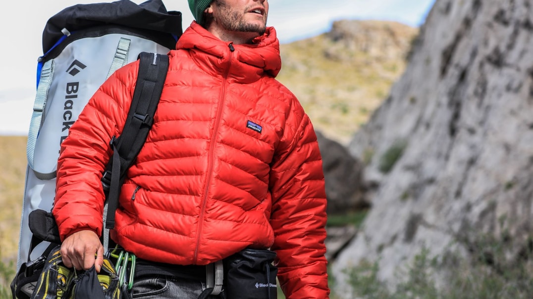 Man wearing red jacket outside with hiking gear