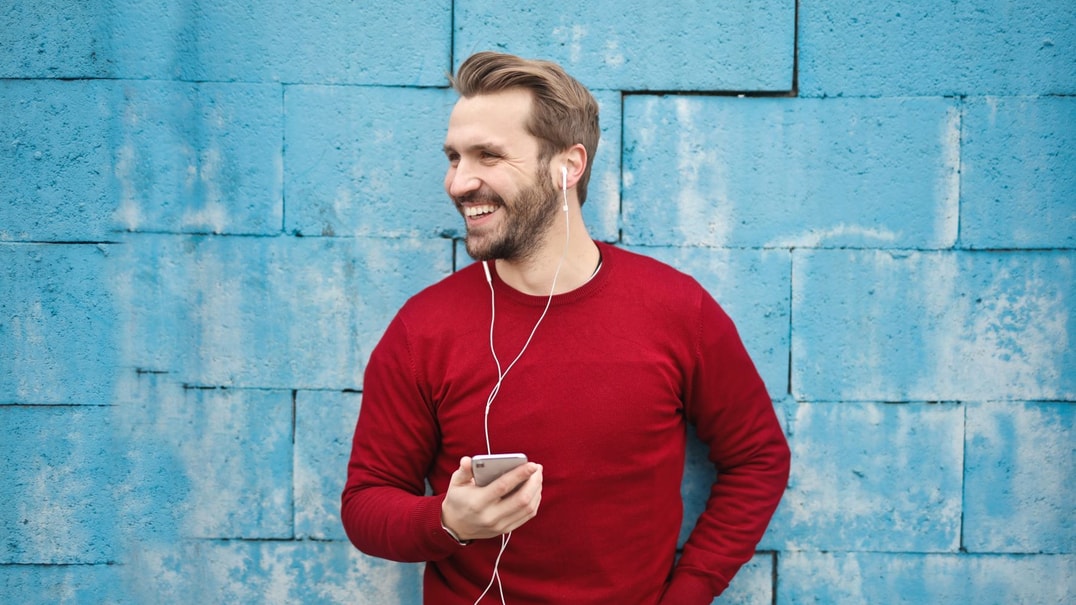 Person in red shirt listens via earphones
