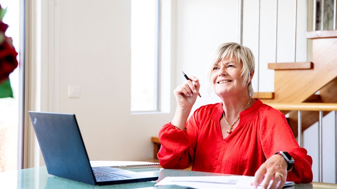 Person wearing red looks up from laptop