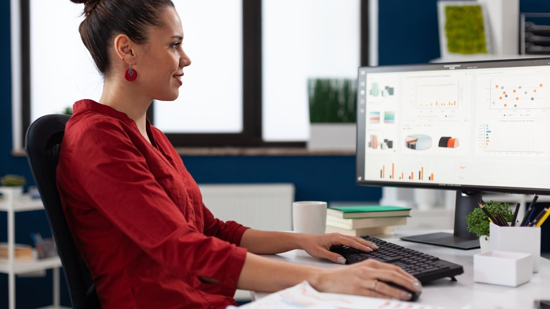 Person wearing red works on a computer