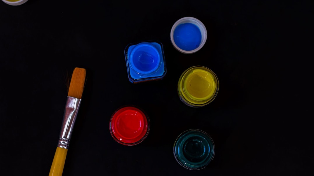 Pots of colourful paint on a black background