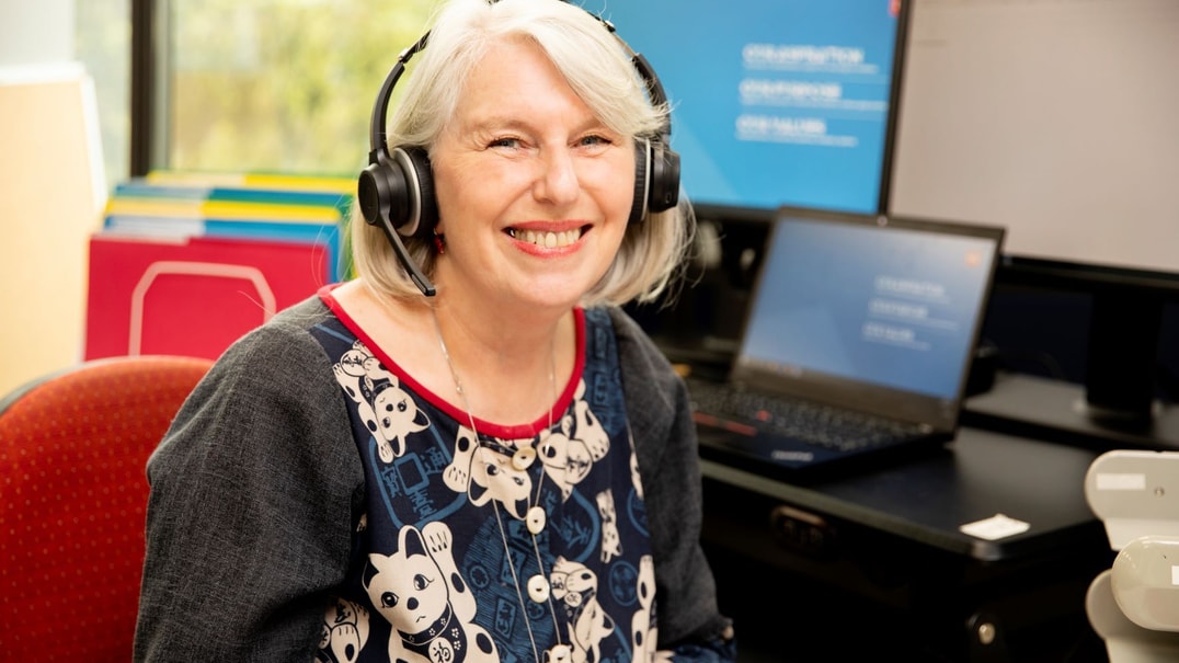 MS employee smiling and wearing a headset