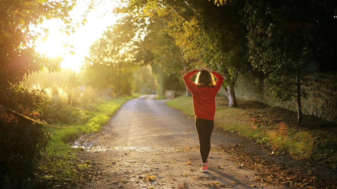 Person walking outdoors at sunset