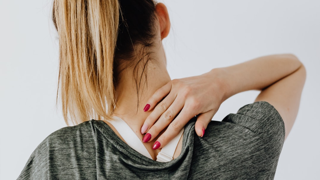 Person holding neck in pain