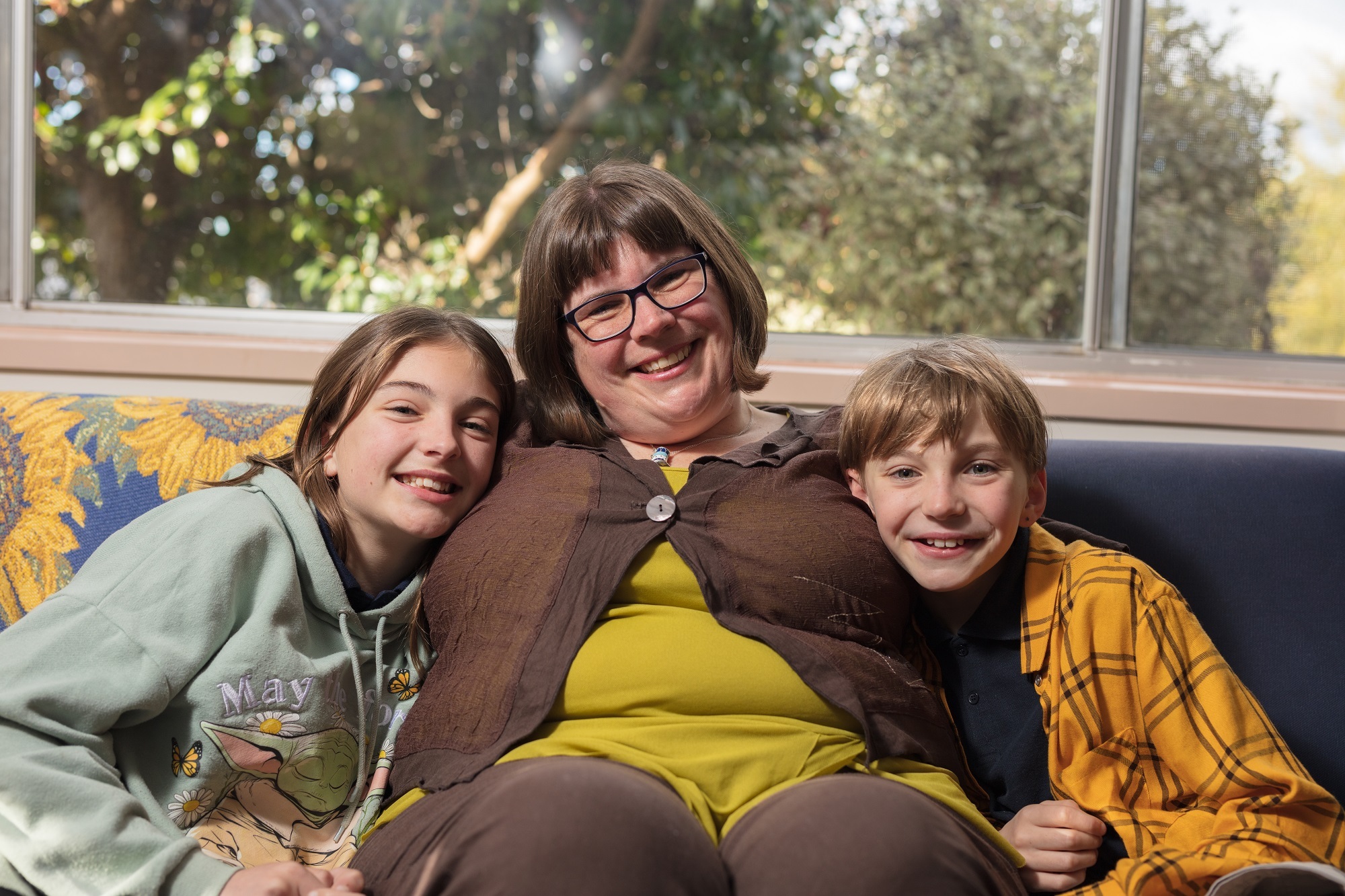 Woman sitting with her children on couch